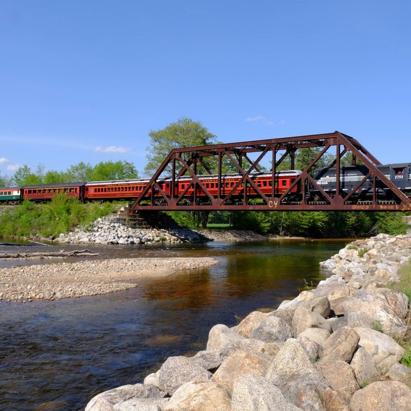 a train crossing a bridge over a body of water