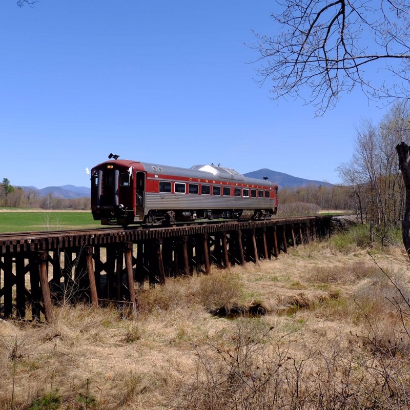 a large long train on a train track with trees in the background