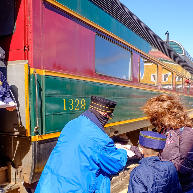 a group of people standing next to a train