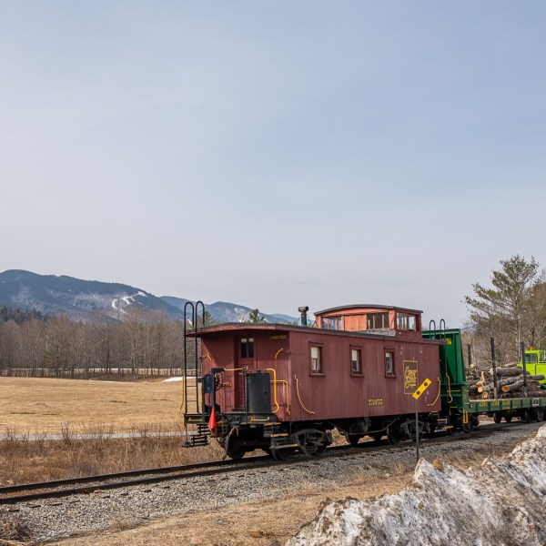 a train traveling down train tracks near a field