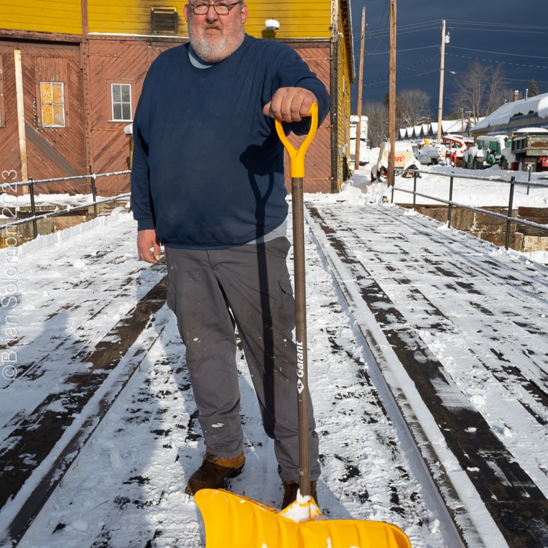 a man standing on a snow board in the parking lot