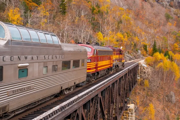 a train traveling down train tracks near a mountain