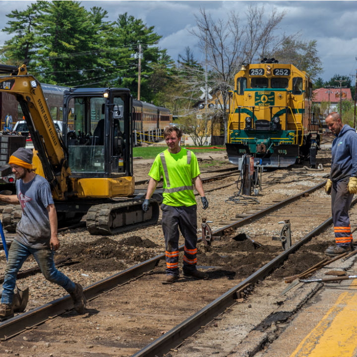 a group of people standing next to a train